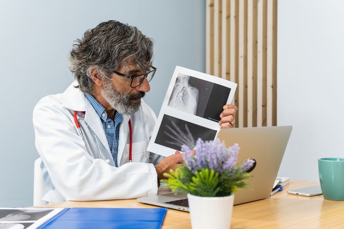 Male doctor using laptop and talking on video call