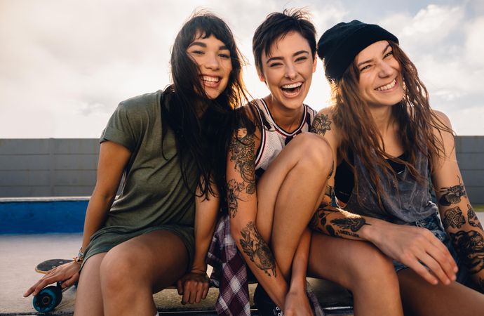 Group of women sitting at skate park and laughing