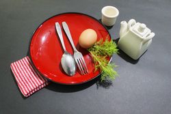 Restaurant Table Setting with Red Plates and Monochromatic Accessories