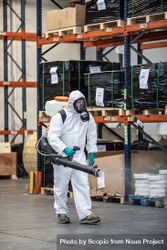 Man in PPE holding sanitizing machine in warehouse 41n3Nb