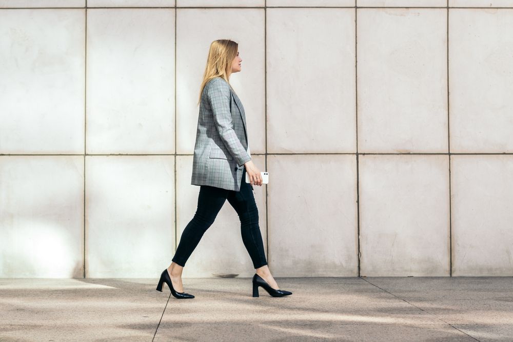 Side view of a businesswoman in a suit and heels on her way to the office