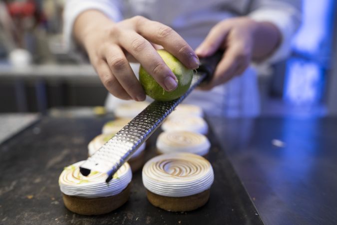 Cook grating lime on meringue cookies