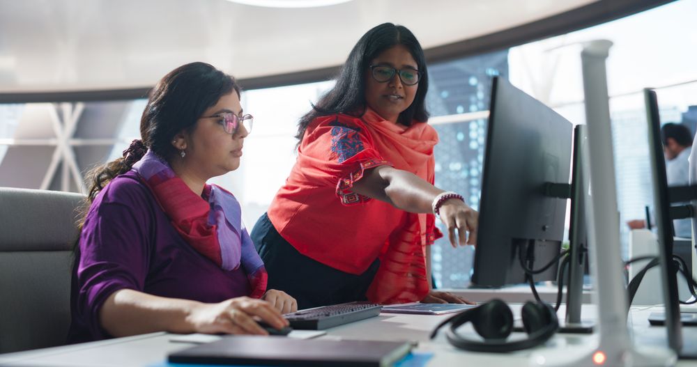 Two Diverse Colleagues Having a Conversation While Busy Working on a Corporate Team Project.