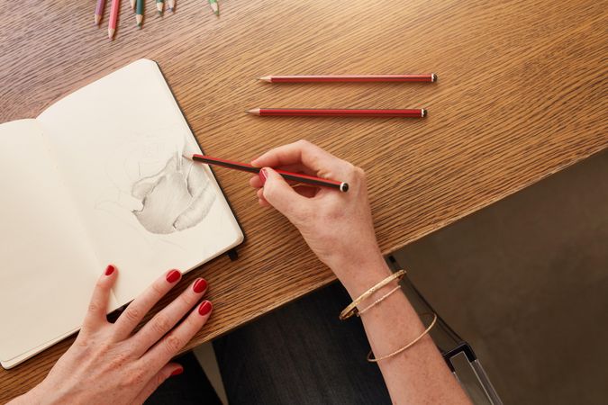 Close up of hands of female artist working with pencil sketch