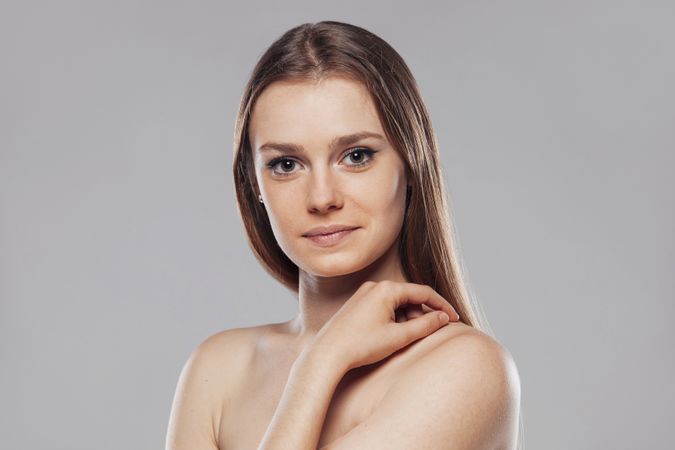 Blond woman without shirt posing in studio