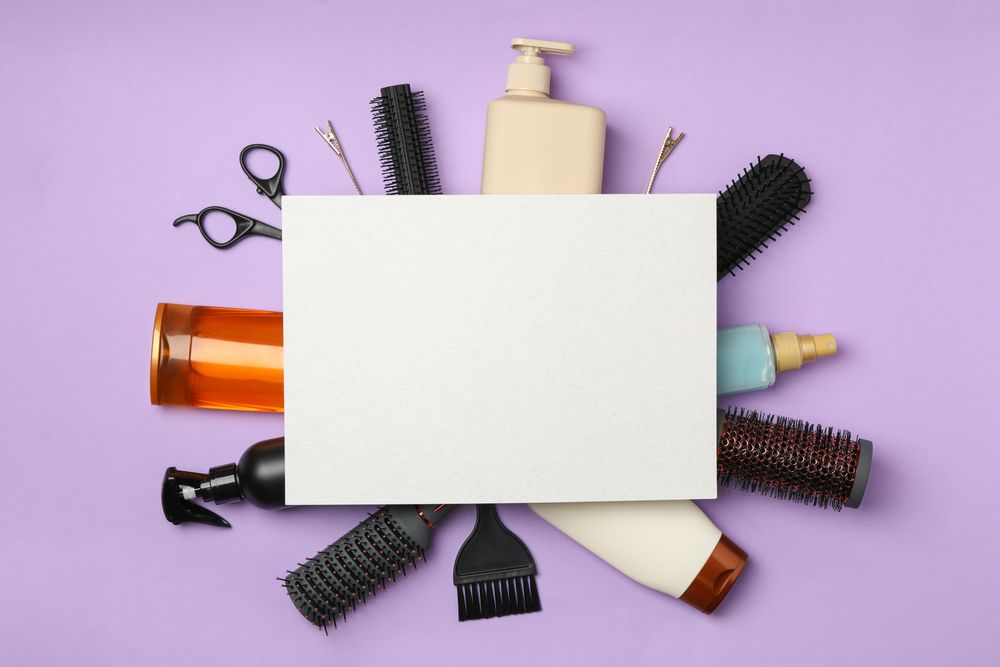 Composition with hairdresser accessories on violet background, space for text