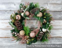 Christmas holiday wreath with illuminated lights on rustic wooden boards 0VjeG0