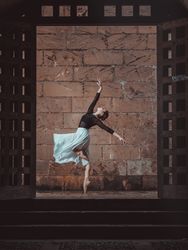 Graceful ballerina dancing in doorway in ancient building