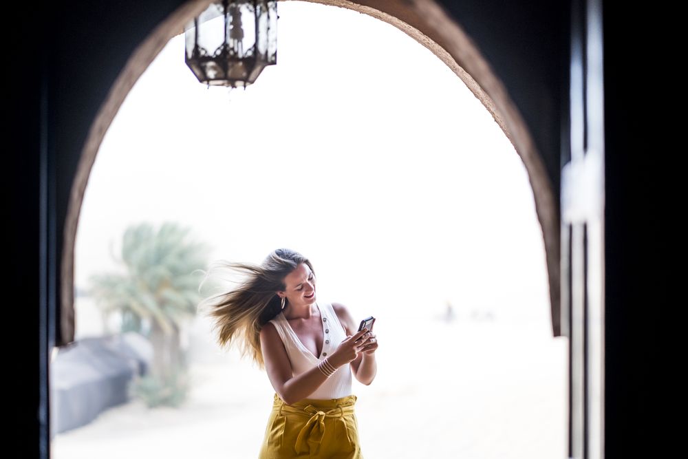 Woman using smartphone in balcony