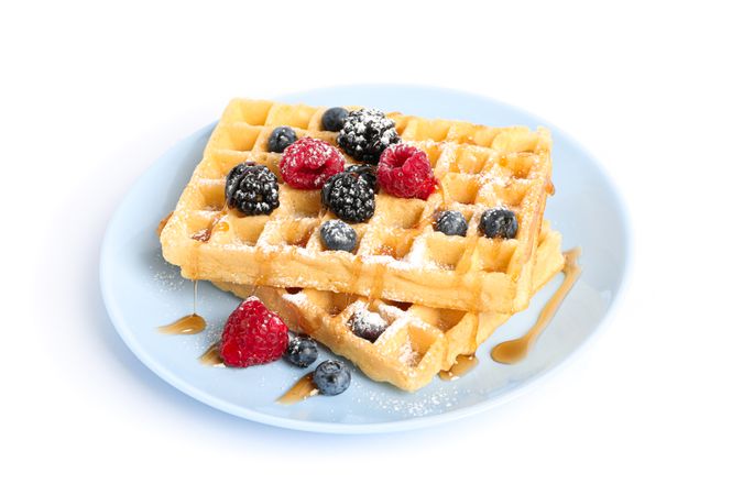 Waffles with berries on plate isolated on blank background
