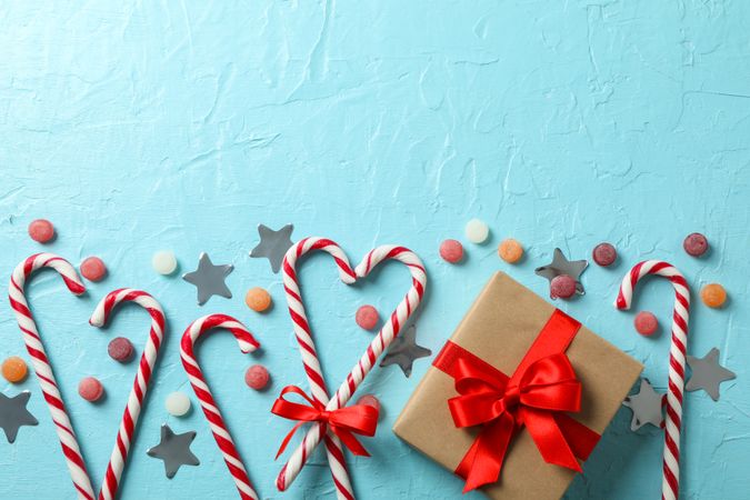 Candy canes and christmas accessories on blue background, space for text