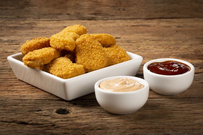 Fried chicken nuggets with ketchp and rose sauce.