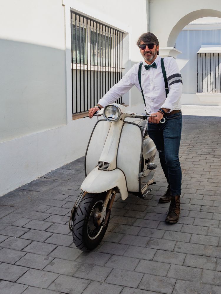 Trendy man sitting on vintage scooter