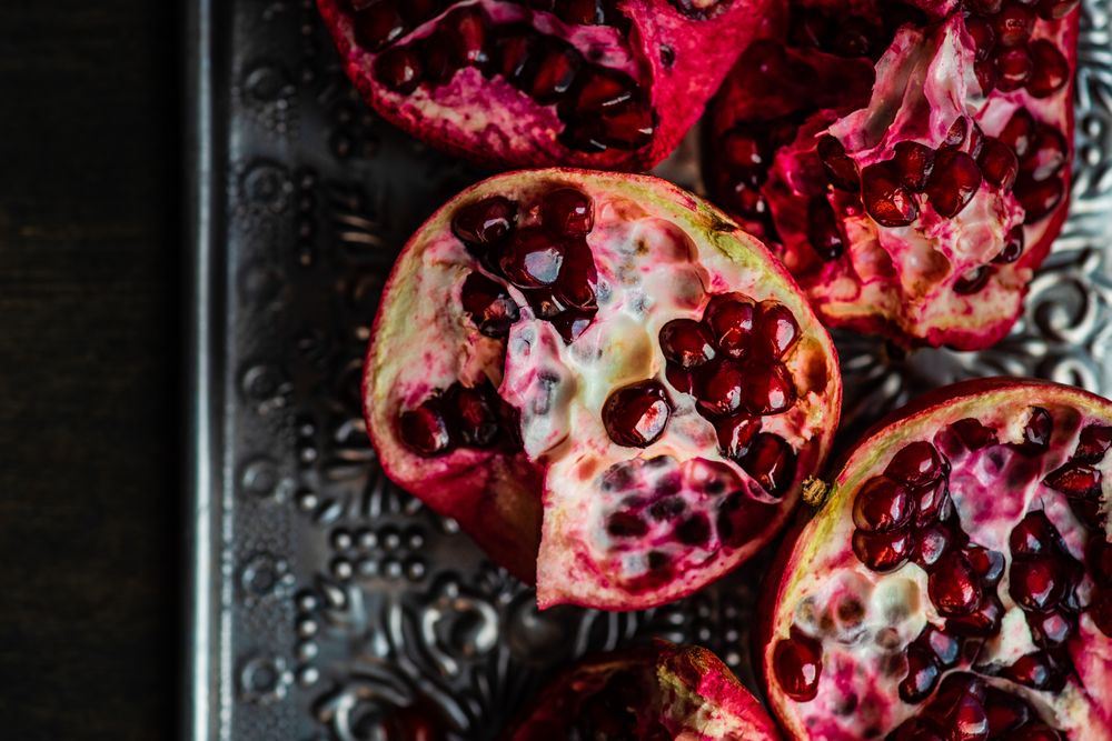 Close up of open pomegranate on silver ornate tray