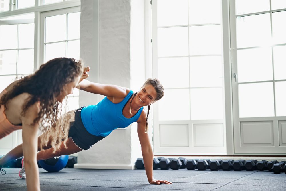 Two woman encouraging each other as they work out together
