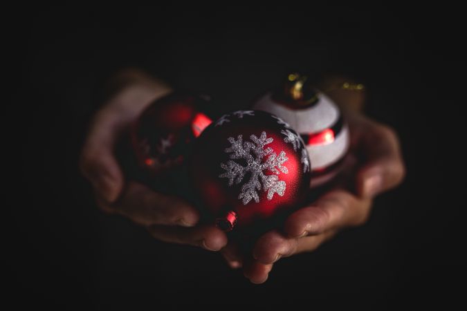 Crop person showing Christmas baubles