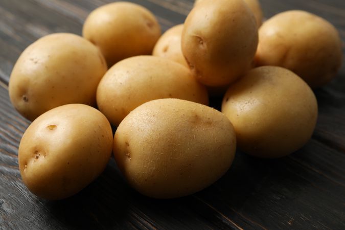 Close up of whole potatoes on dark kitchen table