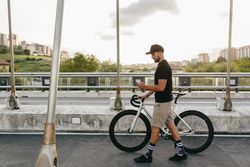 Man walking with bike and using smartphone