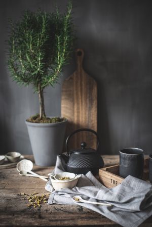 Round teapot and spoons with bowl on linen cloth