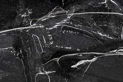 Fragment of thin ice on dark frozen river
