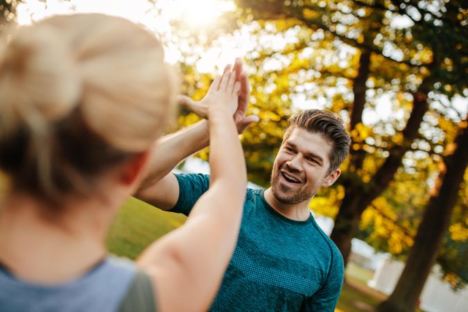 Fitness couple in park giving high five