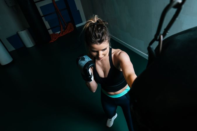 Woman training in gym with punching bag