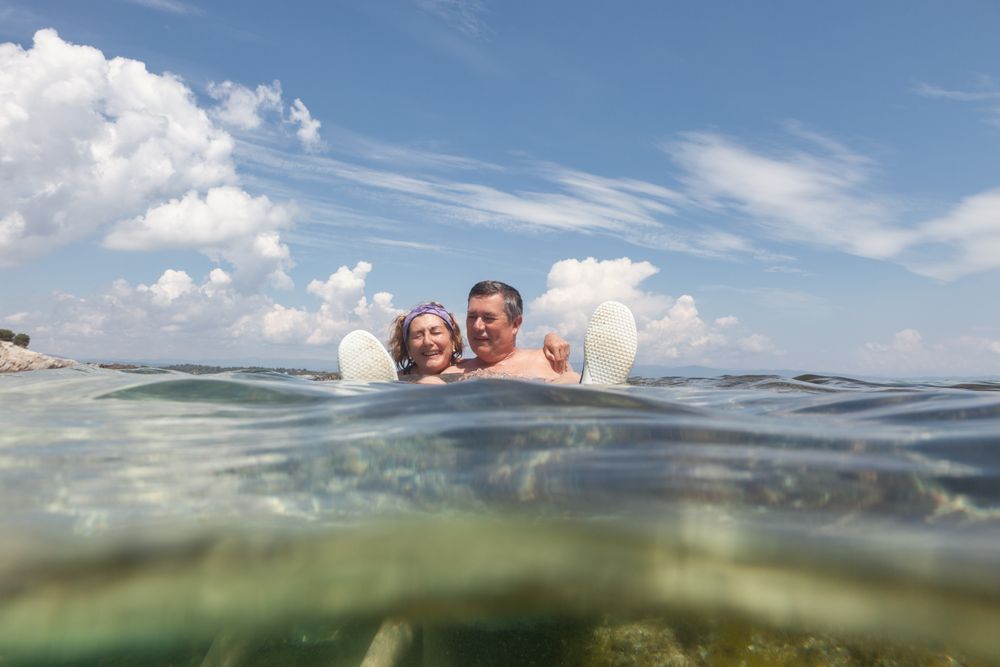 Mature couple swimming together in fresh water