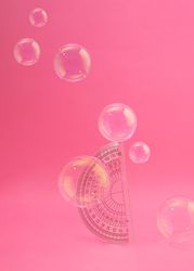 Protractor on pink background with bubbles