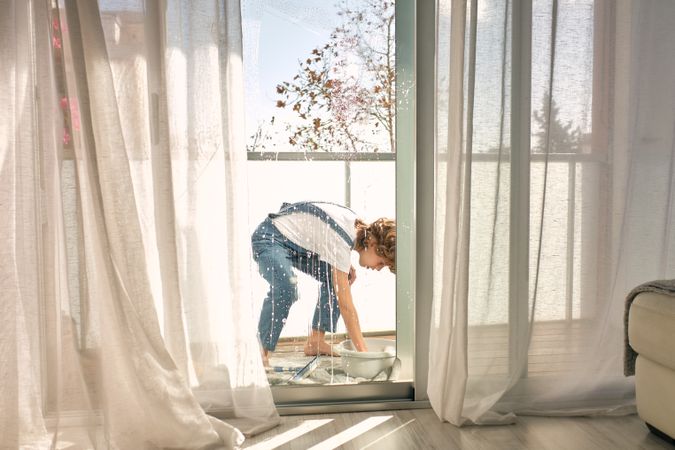 Child cleaning windows at home