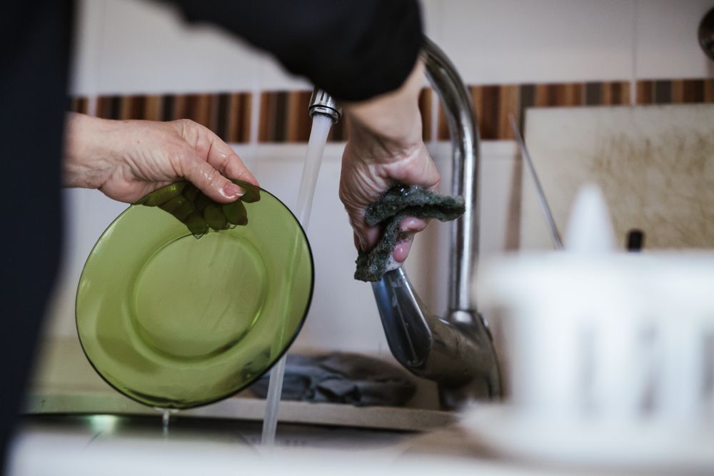Anonymous older woman washing dishes