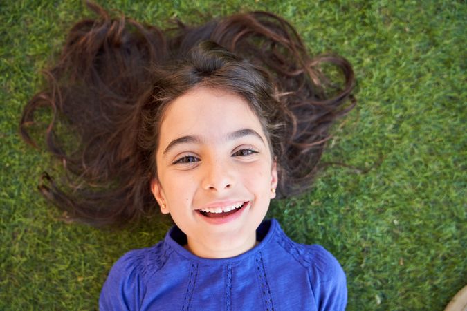 Smiling girl lying on grass