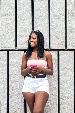 Portrait of a Black young woman enjoying in the city using smartphone