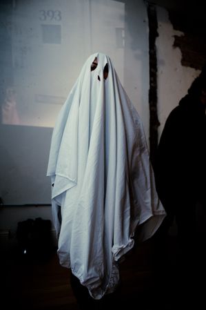 Halloween party with person in sheet ghost costume