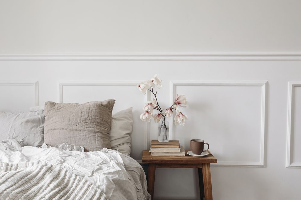 Elegant bedroom with wooden night stand with fluted glass vase