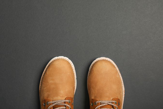 Winter boots on dark background, top view