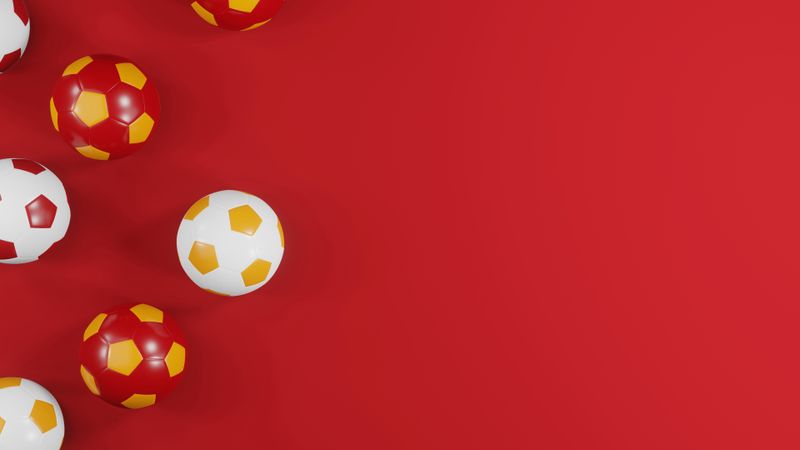Spanish football tribute: Red and yellow soccer balls on red background with copy spacae
