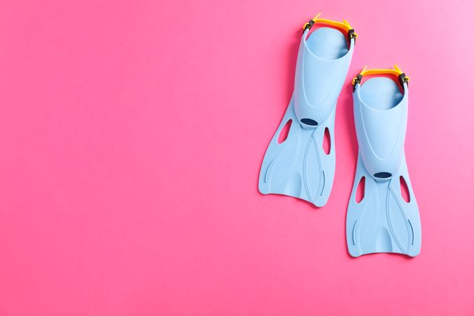 Blue flippers on pink background, space for text