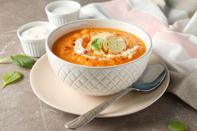 Bowl of pumpkin soup on marble counter