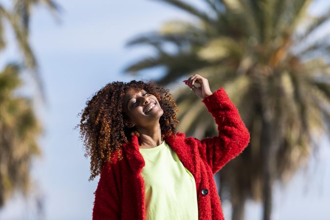 Female with curly hair enjoying the sunshine on her face