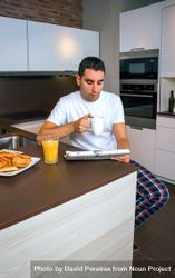 Man reading tablet during breakfast with cup of coffee and pastries 5rR675