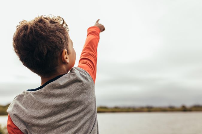 Close up of a boy pointing his finger to the sky