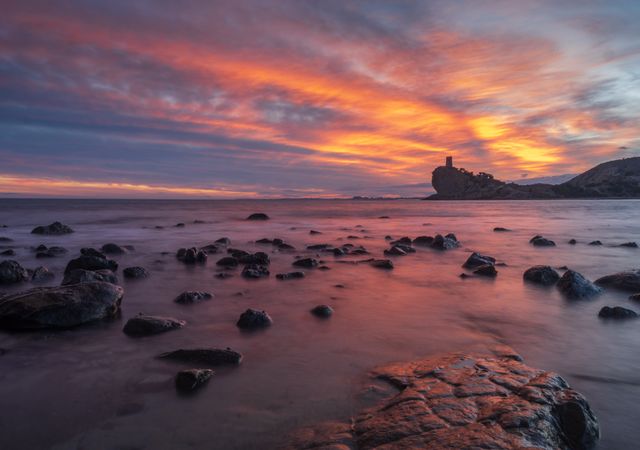 Sundown sky over sea and stony coast