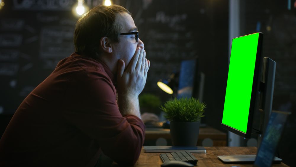 Stressed Office Worker, Exhales and Hits the Table with His Fist in Frustration and Covers His Face in Hands.