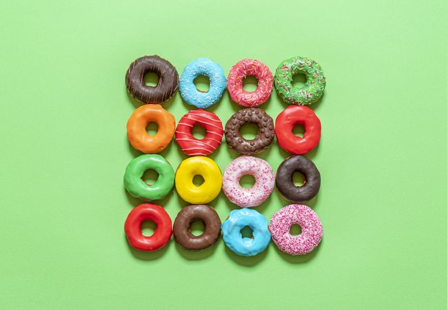 Donuts with icing top view. Multicolored doughnuts on a green background