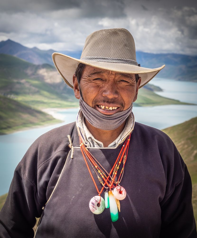 Tibet - August, 29 2014: Tibetan man near river and hills