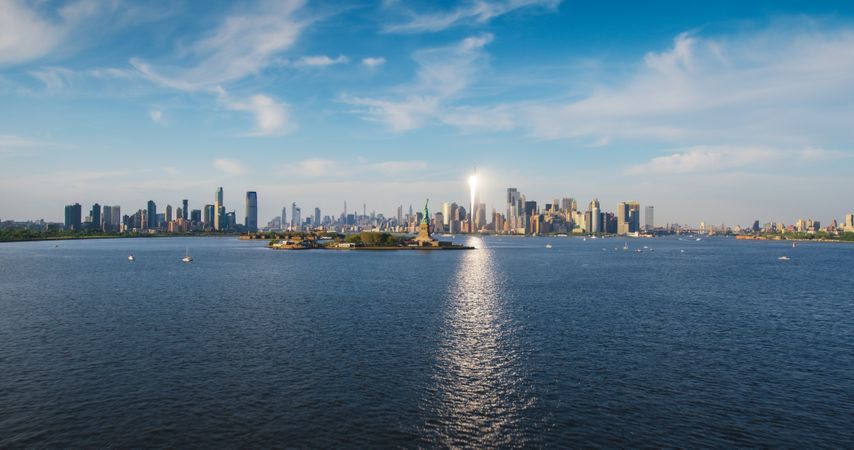 Aerial Shot of the Statue of Liberty with Lower Manhattan Skyline Cityscape with Wall Street Office Architecture. New York City Skyscrapers and Jersey City