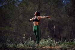 Graceful Hispanic woman meditating in mountains with closed eyes