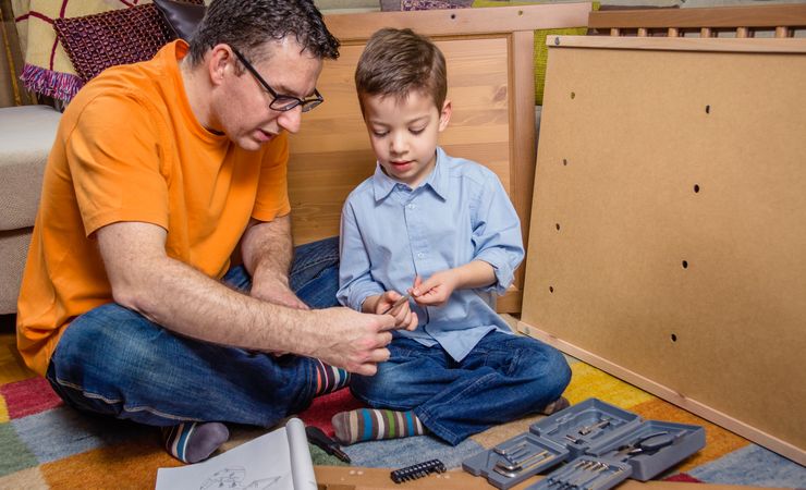Father and son assembling a new furniture for home