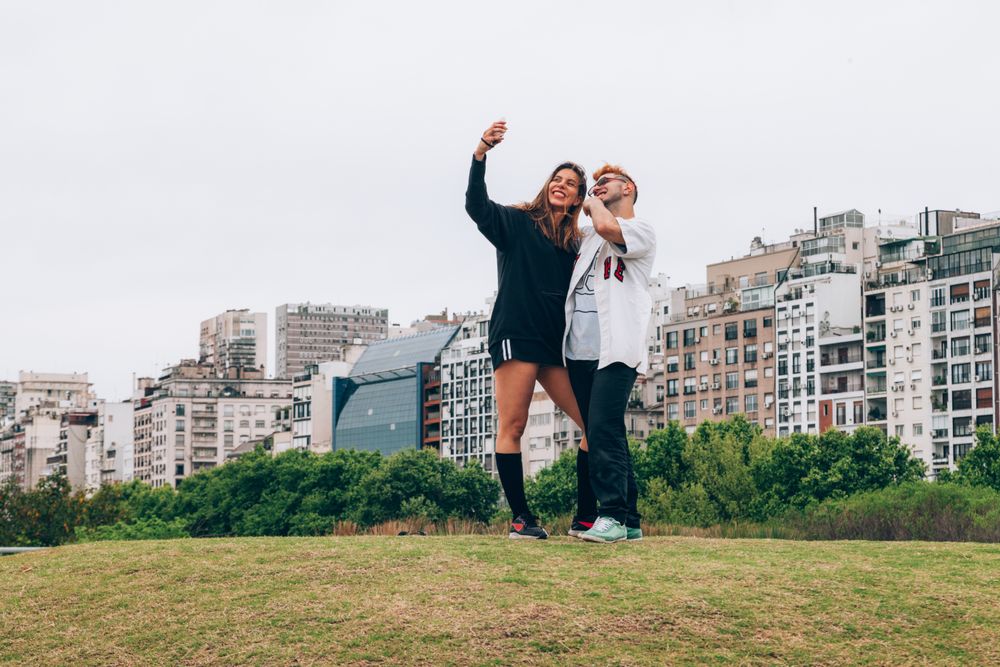 Friends smiling while making selfie on smartphone at city