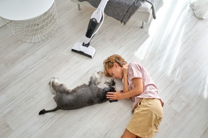 Boy petting dog on floor